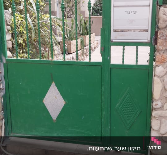 שער ירוק עם אינטרקום ליד בית